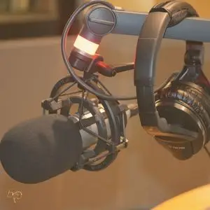 Podcast microphone and headphones set up on a recording arm, ready for broadcast.